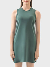 Green sleeveless dress worn by a model on a light gray background