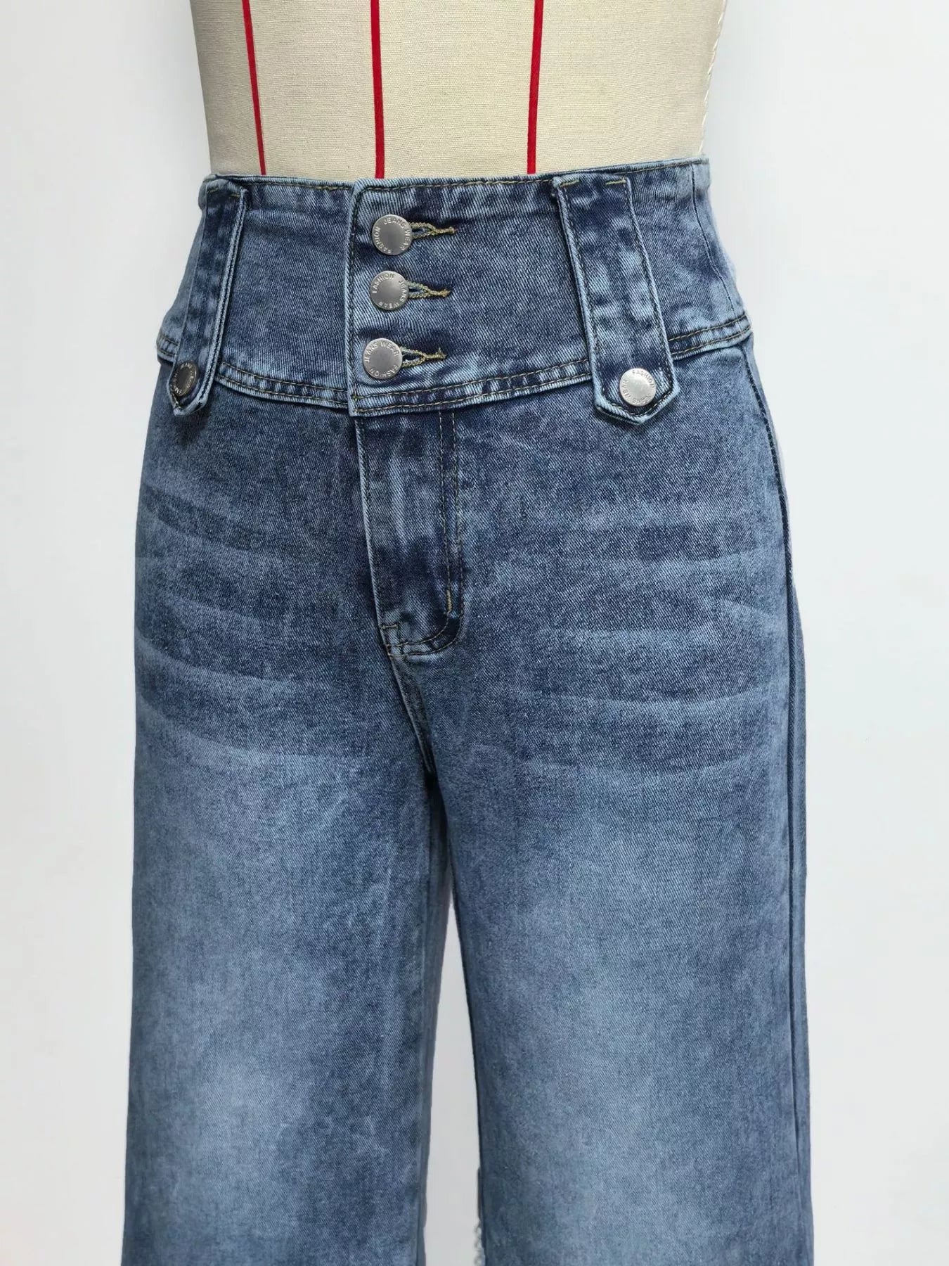 Blue jeans on a mannequin with a white background