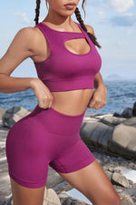 Person wearing a purple athletic outfit standing on a rocky beach.