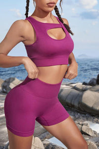 Person wearing a purple athletic outfit standing on a rocky beach.