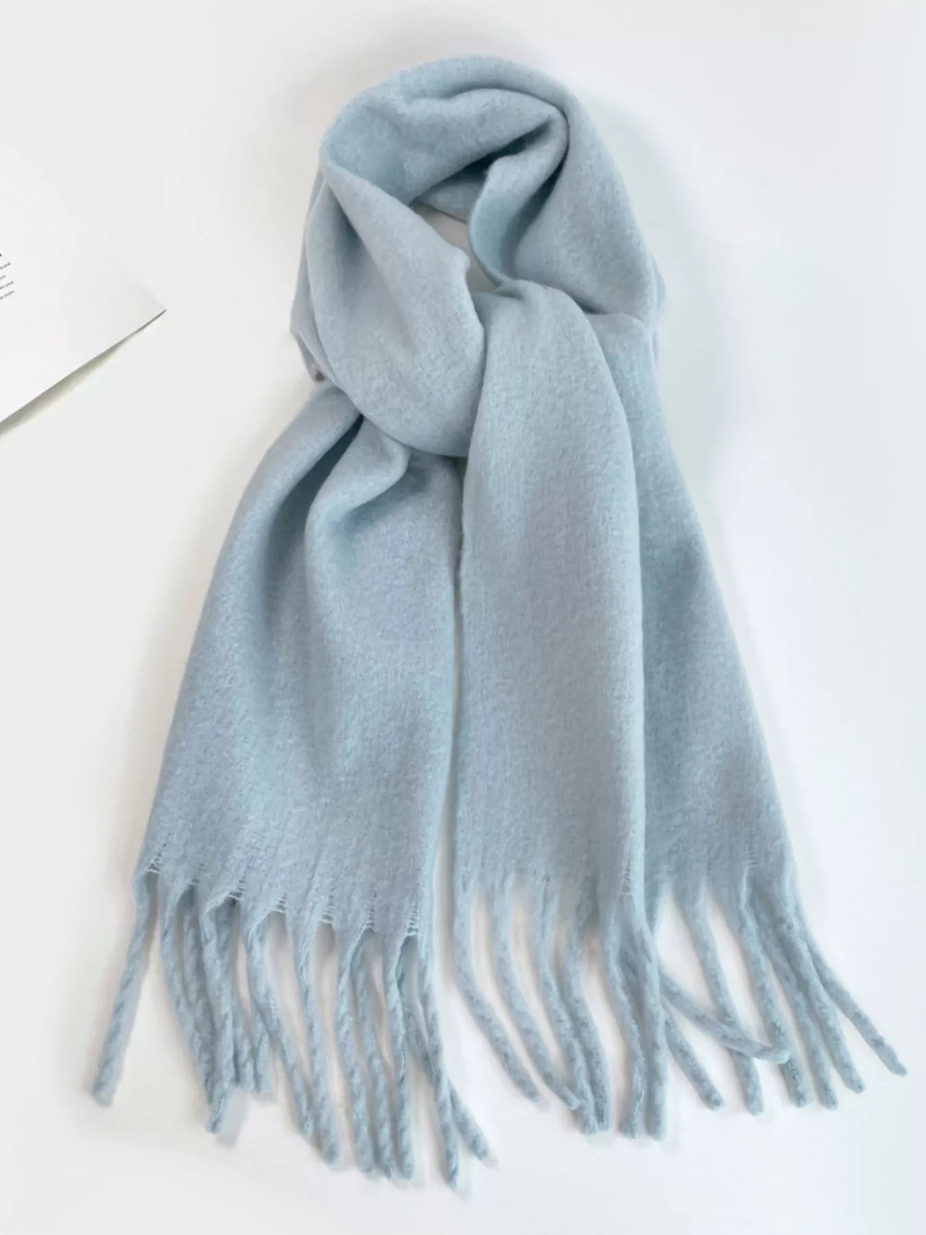 Light blue scarf with fringes on a white background