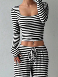 Black and white striped long-sleeve top and pants set on a gray background