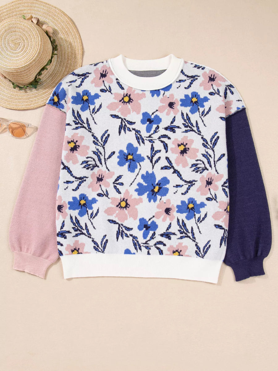 Floral patterned sweater with pink and blue sleeves on a beige background