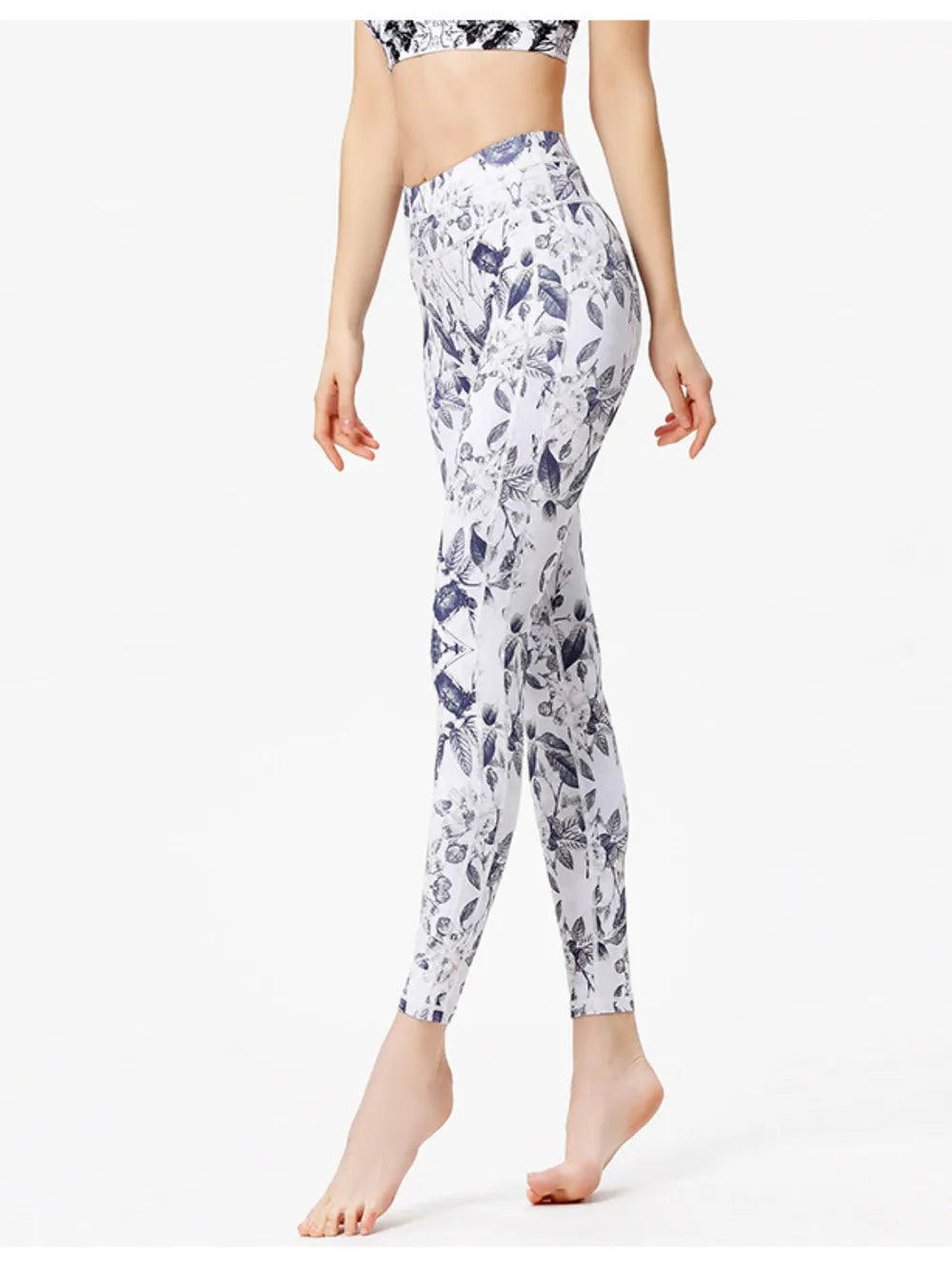 Person wearing white leggings with purple floral pattern on a white background