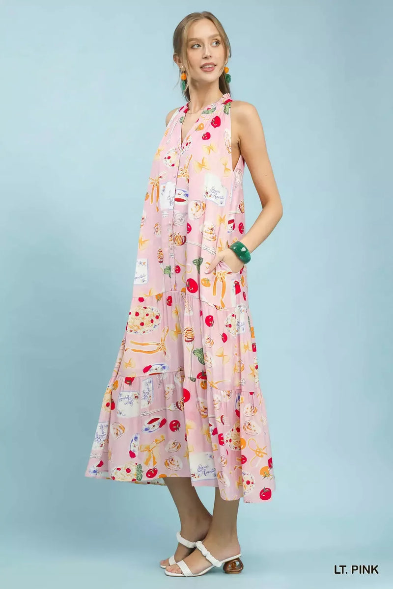 Woman wearing a light pink dress with colorful patterns on a light blue background
