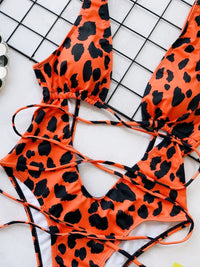 Orange bikini with black leopard print on a grid background