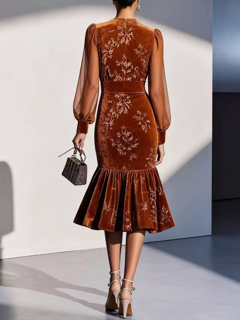 Brown embroidered dress worn by a model against a white wall
