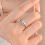 Silver ring with a diamond on a hand against a neutral background