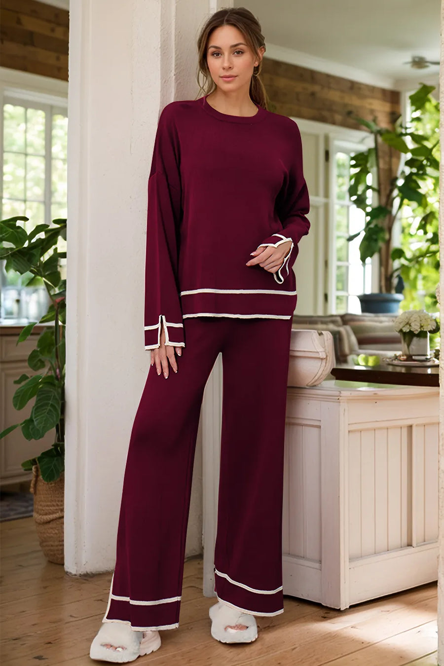 Woman wearing a burgundy outfit with white trim in a kitchen setting
