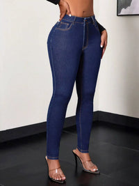 Person wearing blue jeans and high-heeled shoes on a plain background