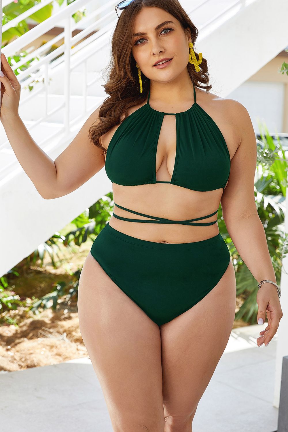 Woman wearing a green bikini set with a white background