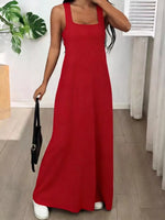 Person wearing a red dress holding a black handbag indoors.