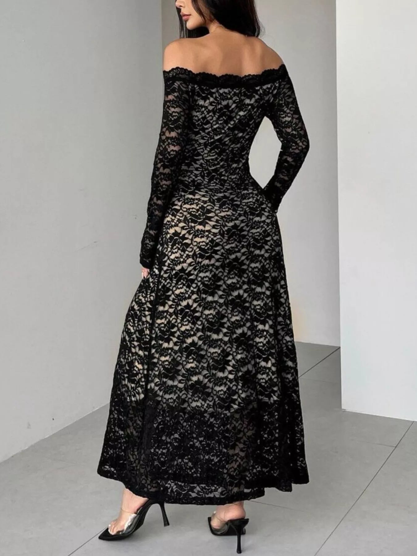 Black lace off-shoulder dress worn by a person against a plain background
