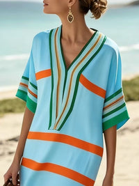 Woman wearing a colorful striped dress on a beach