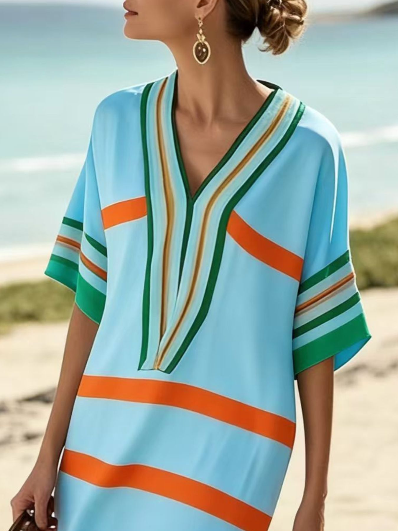 Woman wearing a colorful striped dress on a beach