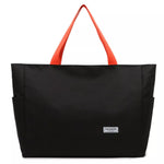 Black tote bag with orange handles on a white background