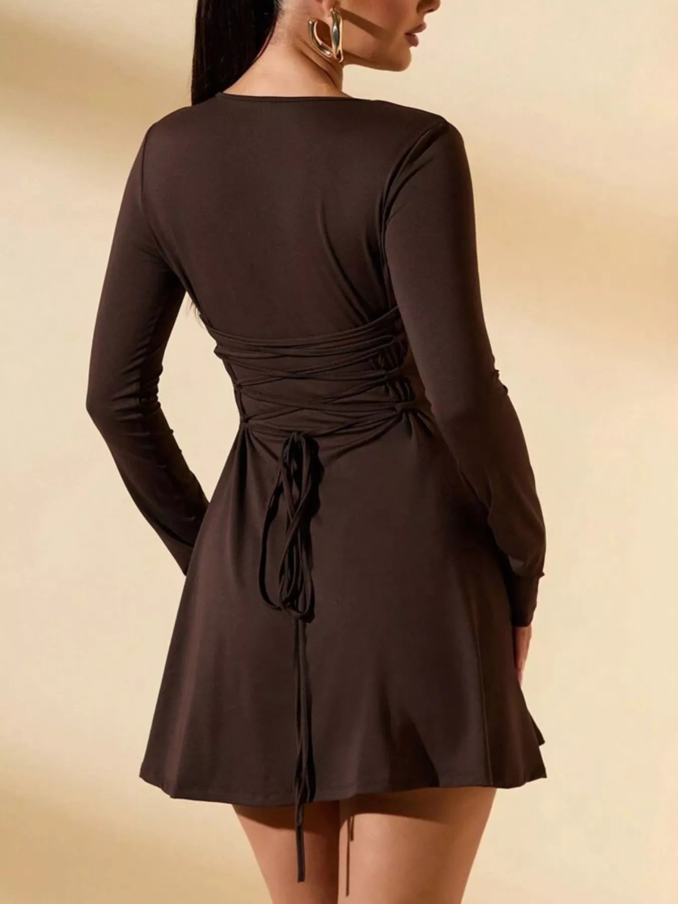 Brown long-sleeve dress with a tie waist on a beige background