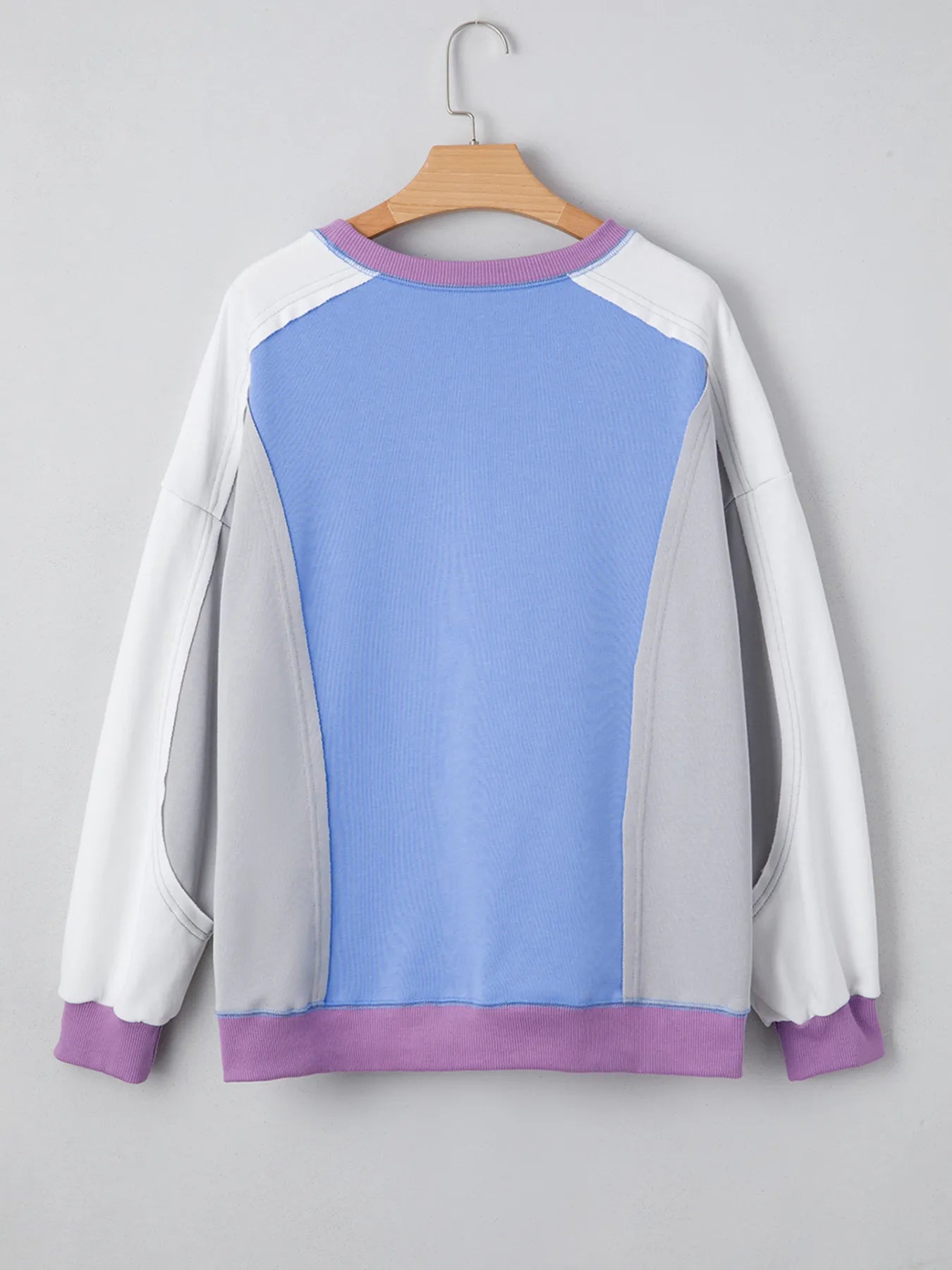 Color-blocked sweatshirt with blue and purple accents on a gray background