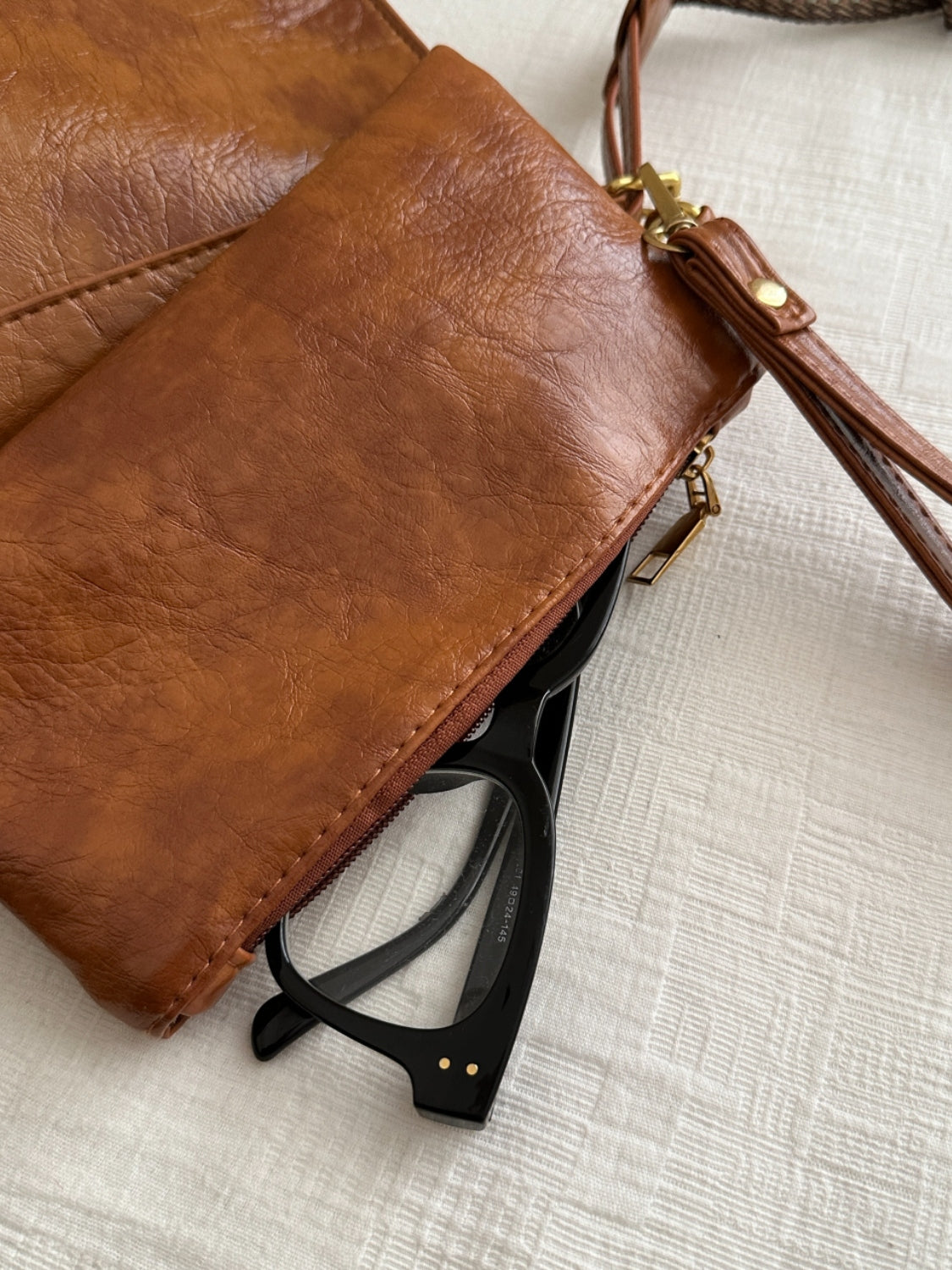 A view of the pouch on brown PU Leather Adjustable Strap Crossbody Bag with Pouch