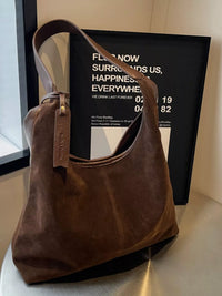 Brown leather handbag on a surface with a blurred background