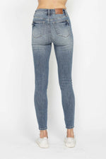 Blue jeans worn by a person on a white background