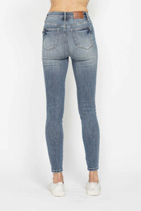 Blue jeans worn by a person on a white background