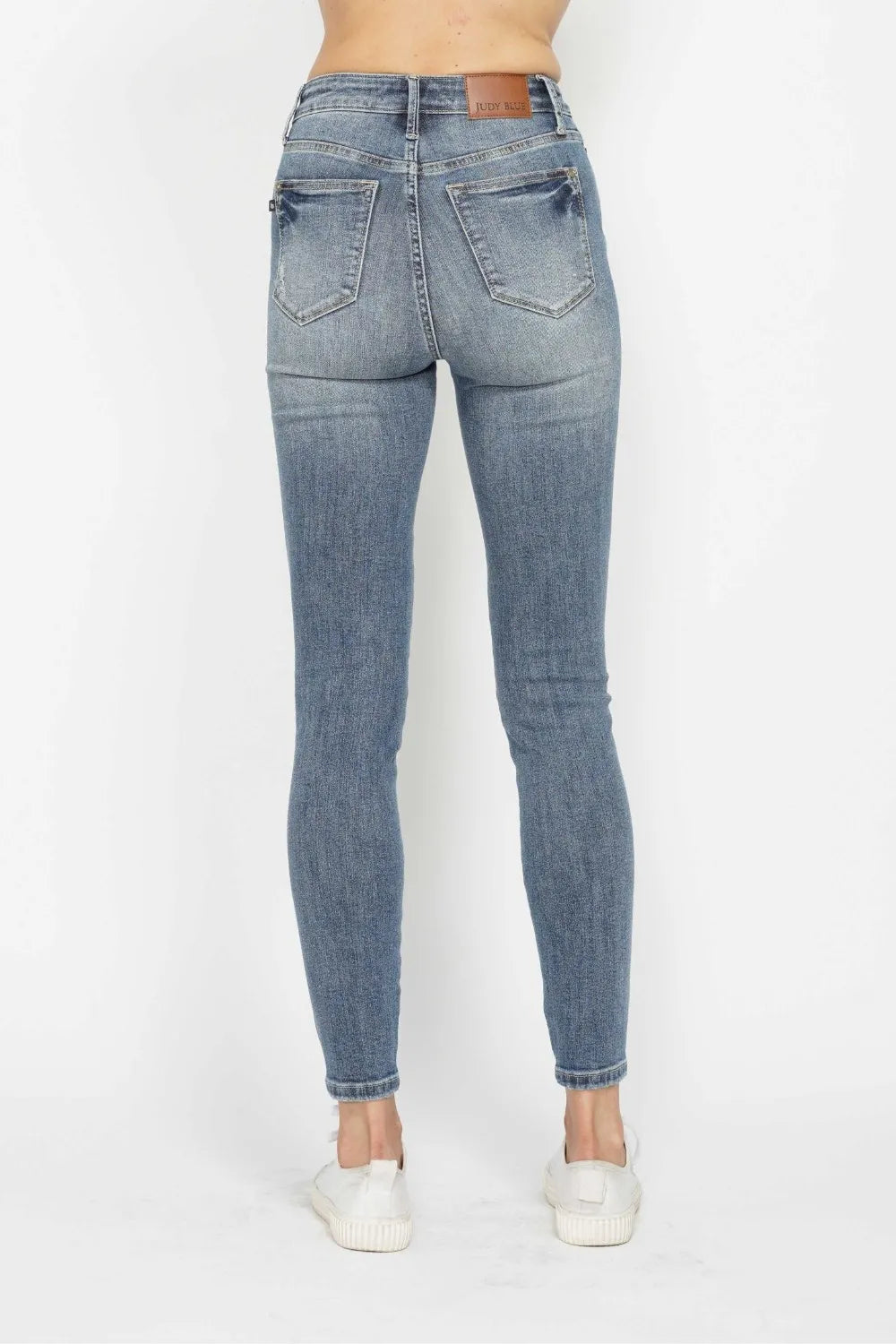 Blue jeans worn by a person on a white background