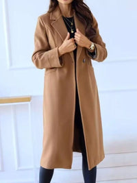 Woman wearing a long brown coat against a white background