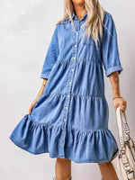 Woman wearing a blue denim dress against a plain background