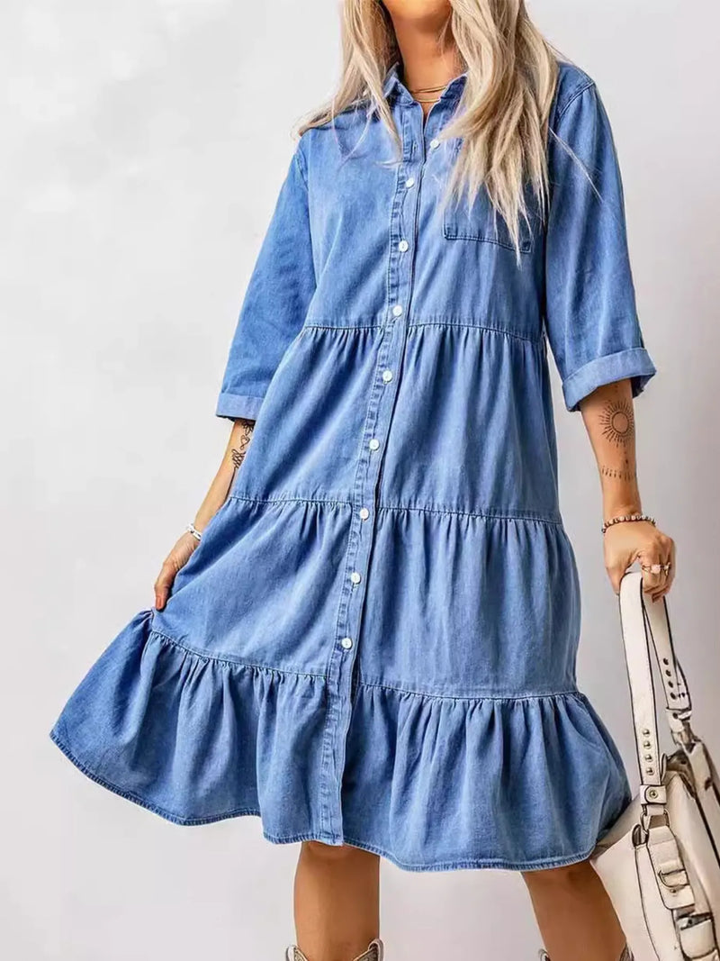 Woman wearing a blue denim dress against a plain background