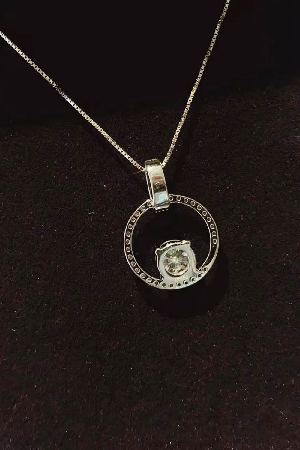 Silver necklace with a pendant on a dark background