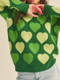 Green sweater with heart patterns worn by a person