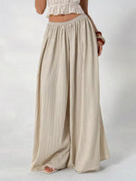Beige wide-leg pants worn by a person on a white background
