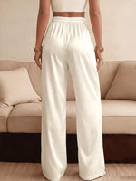 Person wearing white pants standing in front of a beige sofa.