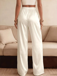 Person wearing white pants standing in front of a beige sofa.