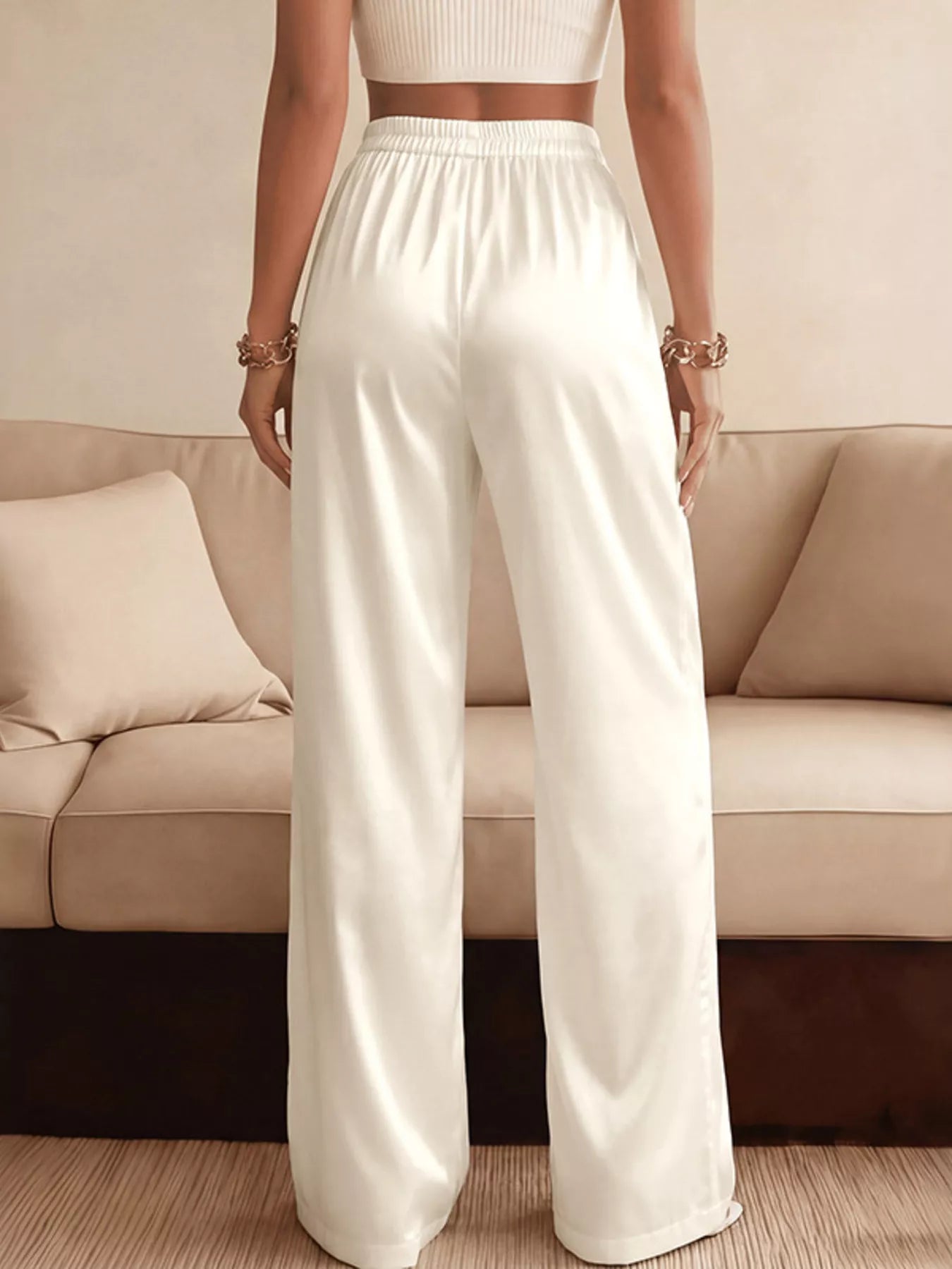Person wearing white pants standing in front of a beige sofa.