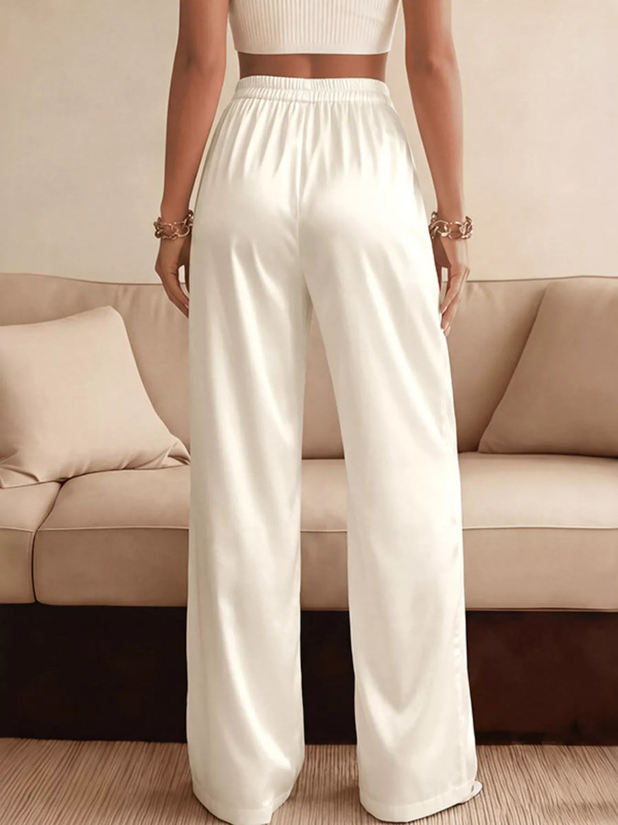 Person wearing white pants standing in front of a beige sofa.