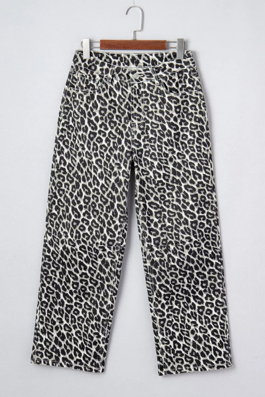 Leopard print pants on a hanger against a white background