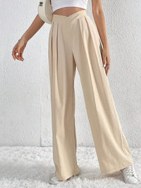 Beige wide-leg pants worn by a person on a white background