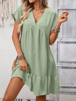 Woman wearing a green dress with a neutral background
