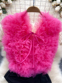 Pink ruffled bag on a hanger against a wire mesh background
