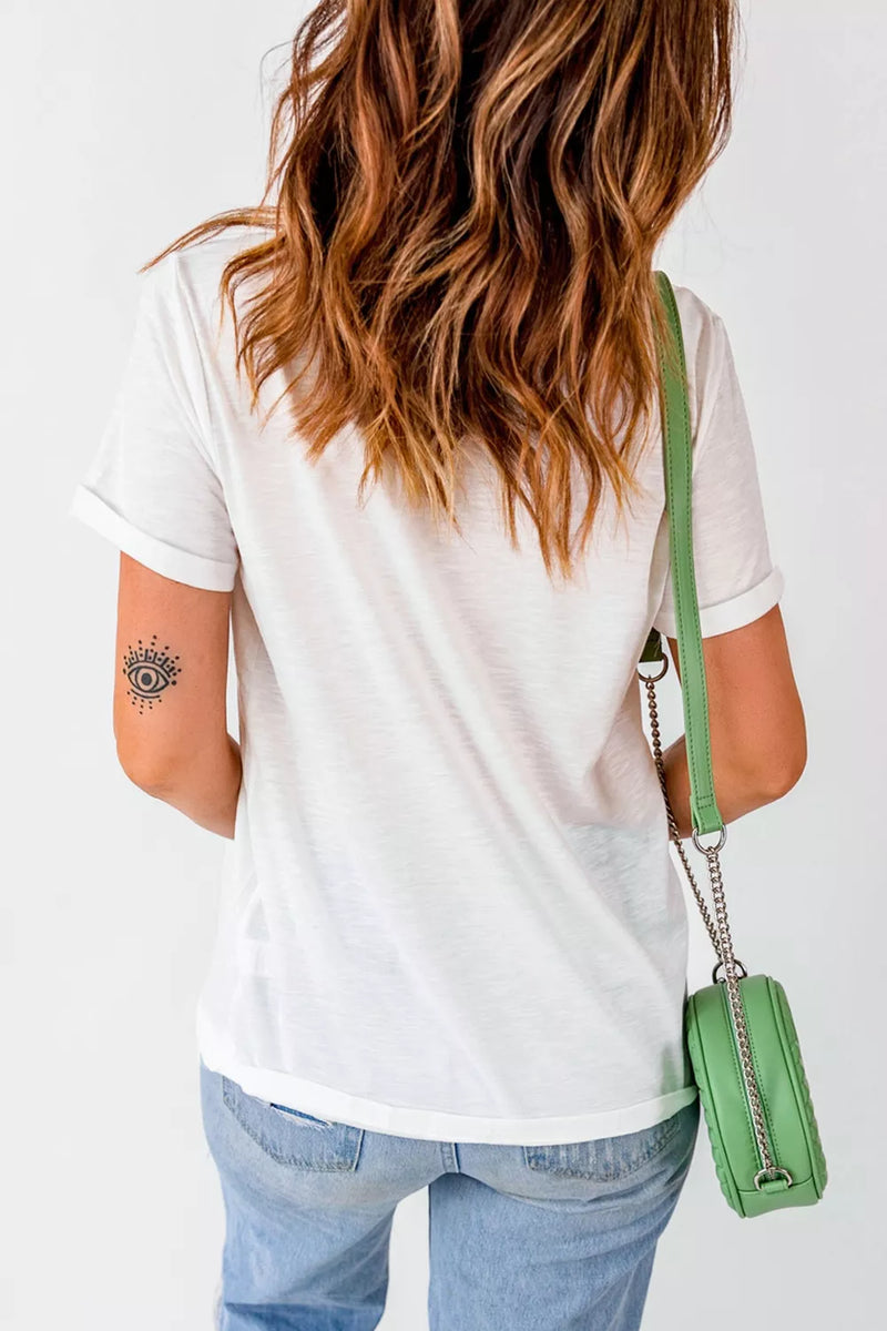 Person wearing a white t-shirt and blue jeans with a green handbag on a plain background