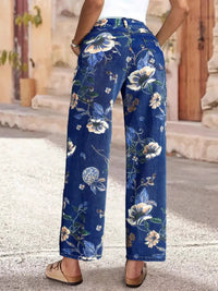 Blue floral pants worn by a person on a stone pavement.