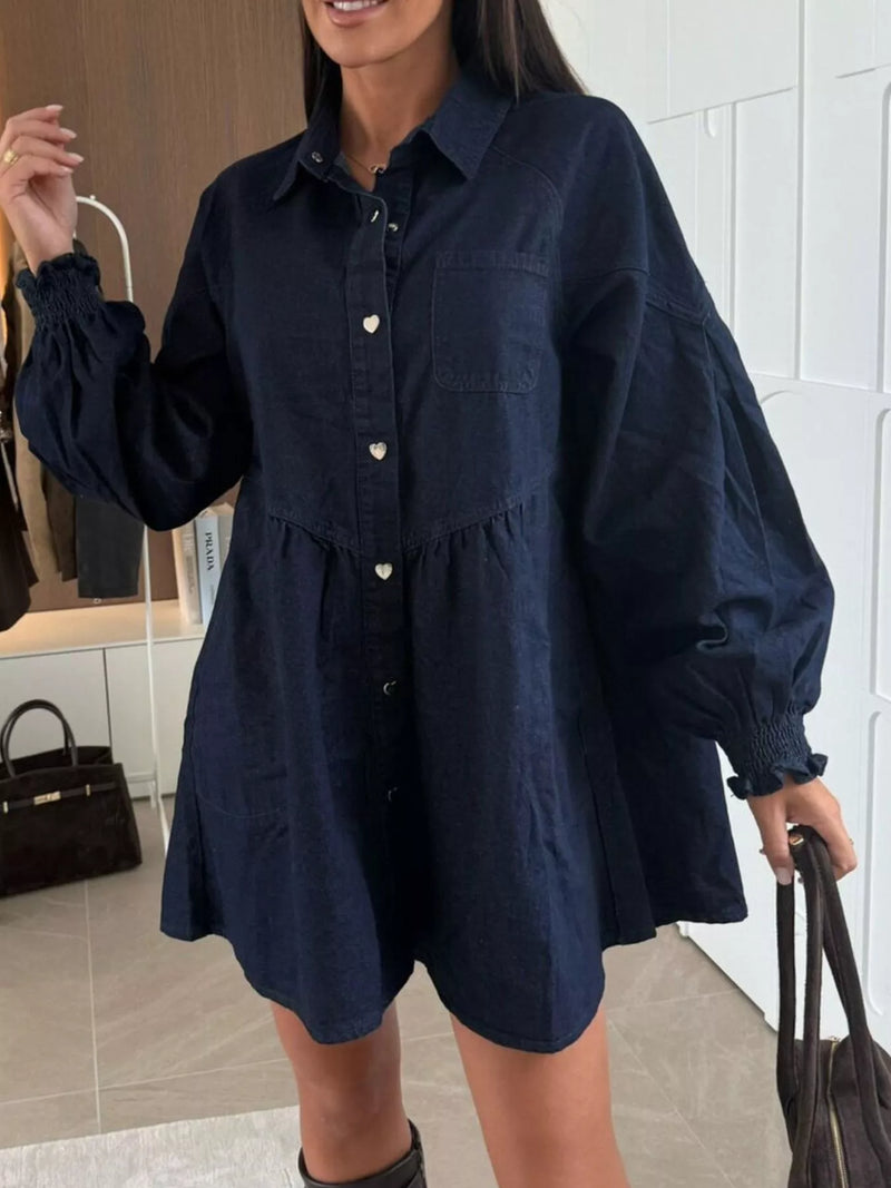 Woman wearing a navy blue dress with long sleeves in an indoor setting.
