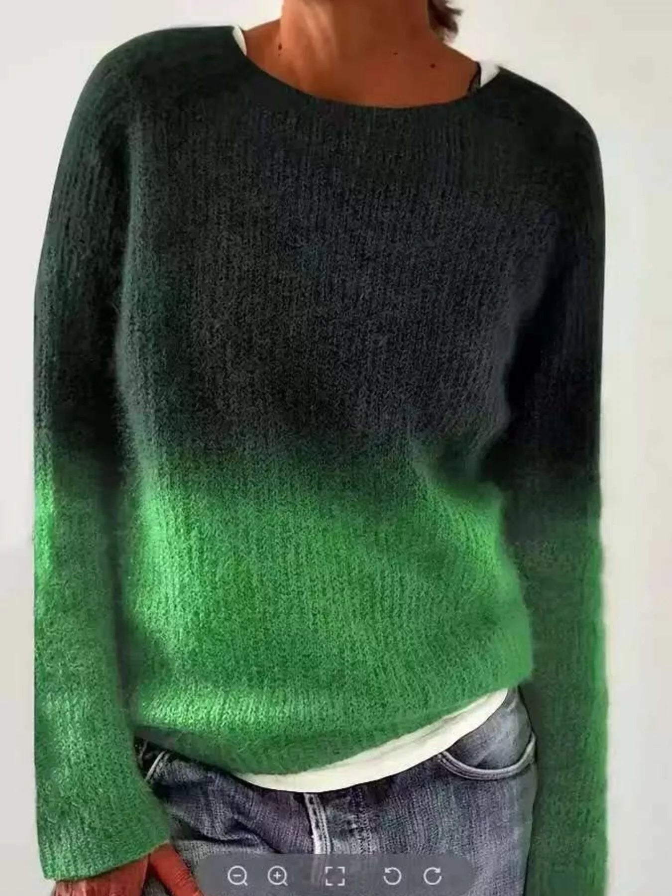 Green and black gradient sweater worn by a person on a white background