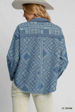 Person wearing a light denim patterned shirt on a plain background