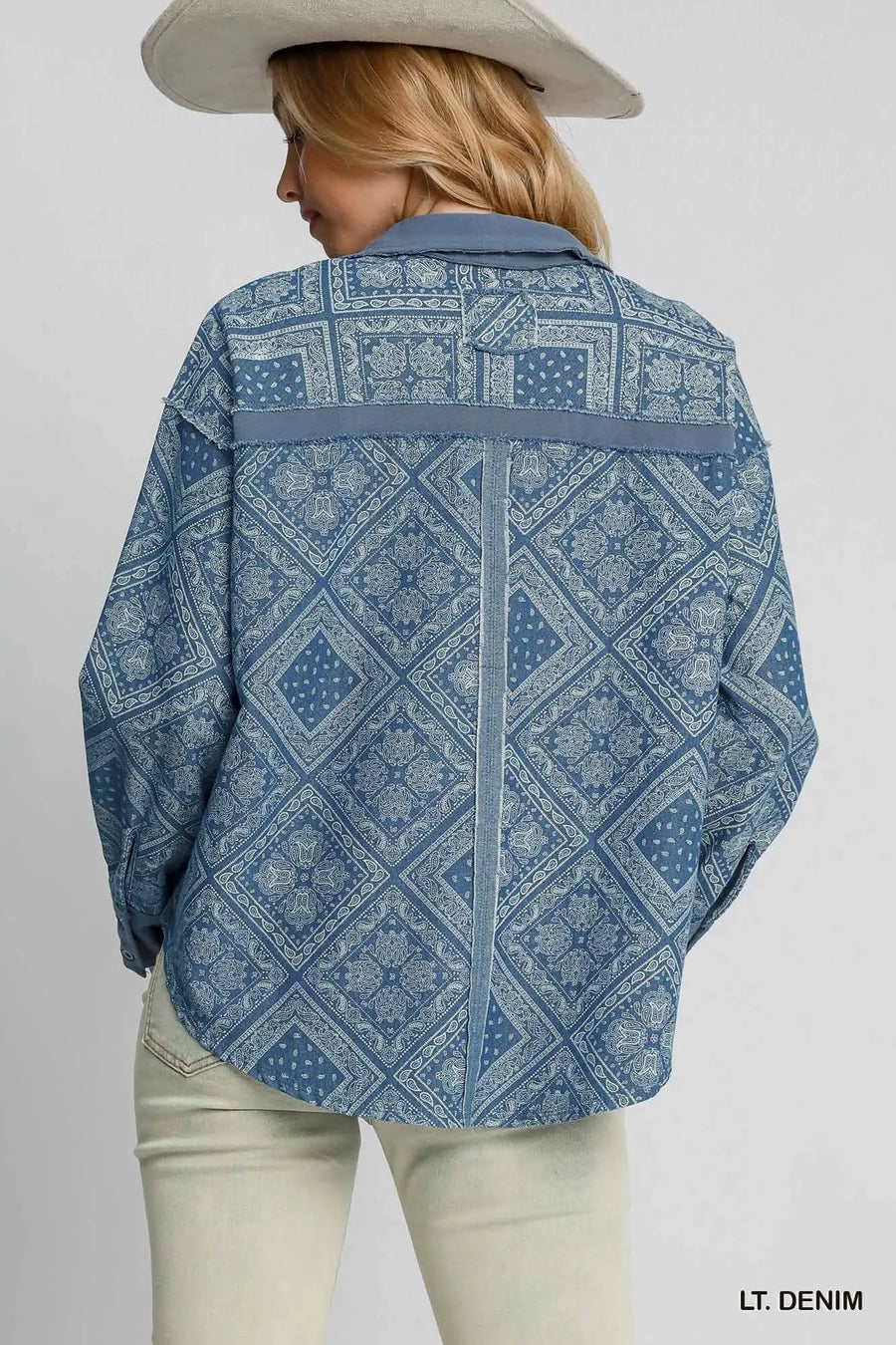 Person wearing a light denim patterned shirt on a plain background