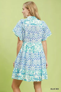 Woman wearing a blue and green patterned dress on a light green background