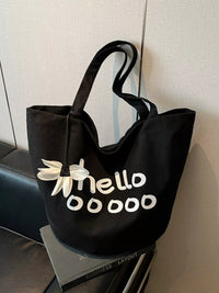 Black tote bag with 'hello dddd' text on a textured surface
