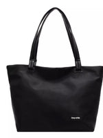 Black tote bag with a visible brand label on a white background